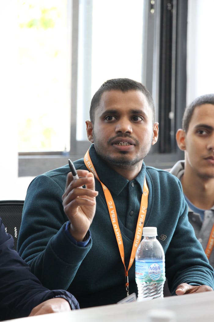 University students actively participating in a seminar, discussing finance and management topics.